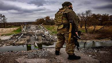 جندي أوكراني من الكتيبة 127 يقف بجوار جسر مدمر قريب من الحدود الأوكرانية الروسية قرب قرية ستاريتسيا، خاركوف
